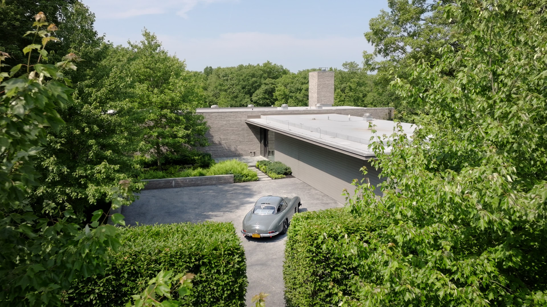 Bedford Quarry — High-angle view of the classic car against the stone and glass facade