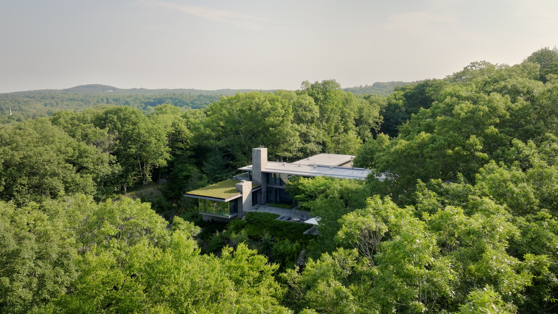 Bedford Quarry — Aerial view of the flat-roofed residence within the forest canopy