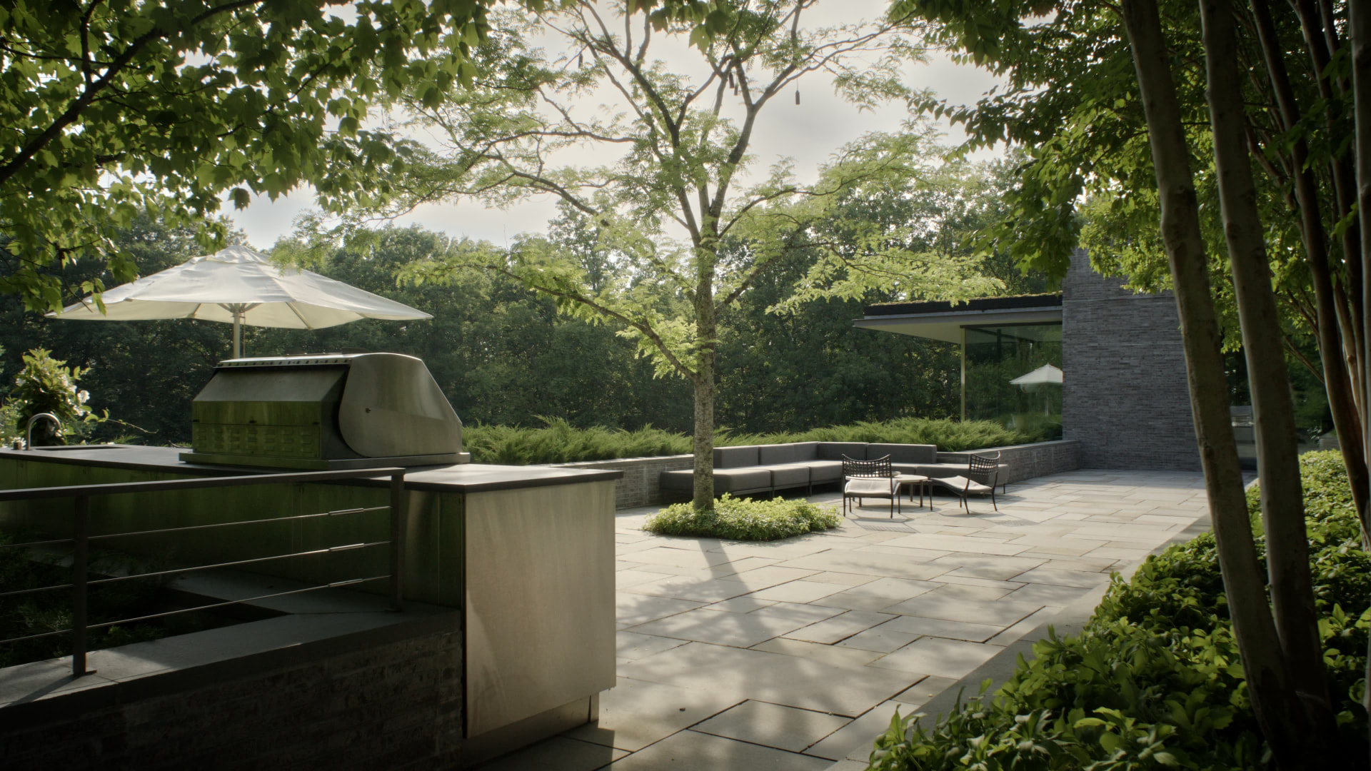 Bedford Quarry — Stone terrace with outdoor kitchen, seating and mature trees