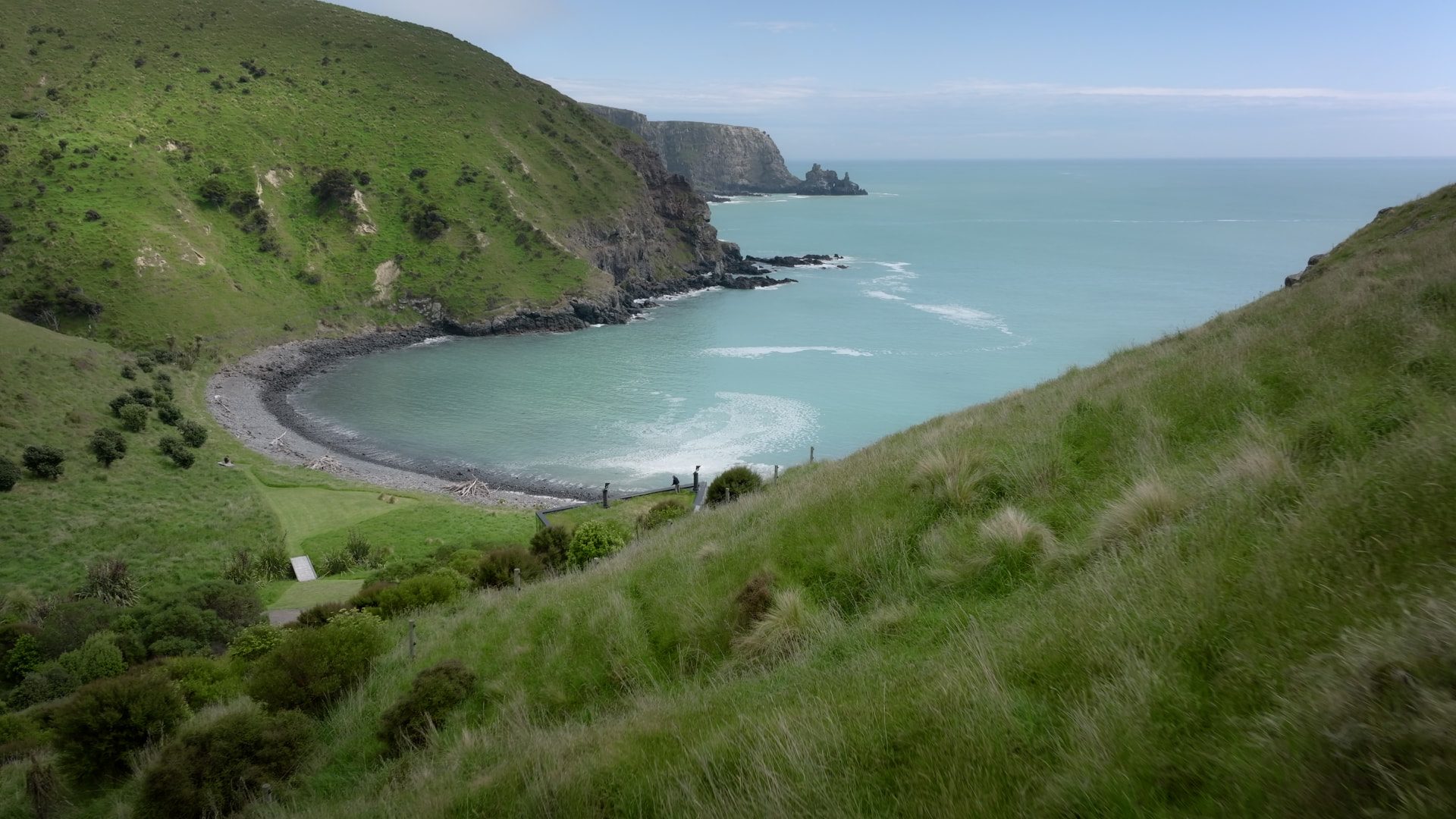 Seascape — a sheltered pebble bay below green headlands on the Banks Peninsula coast